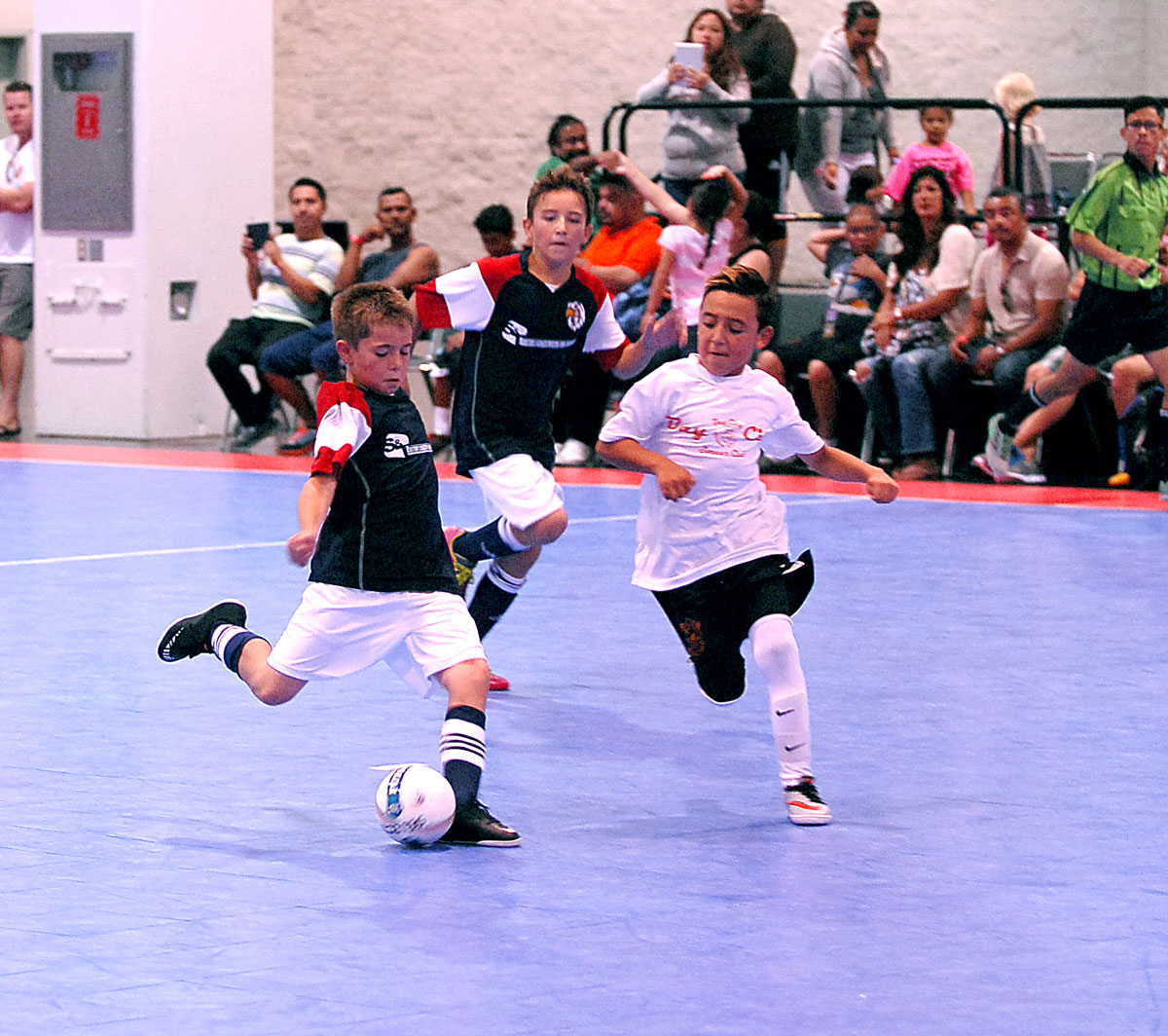 Three young boys playing futsal