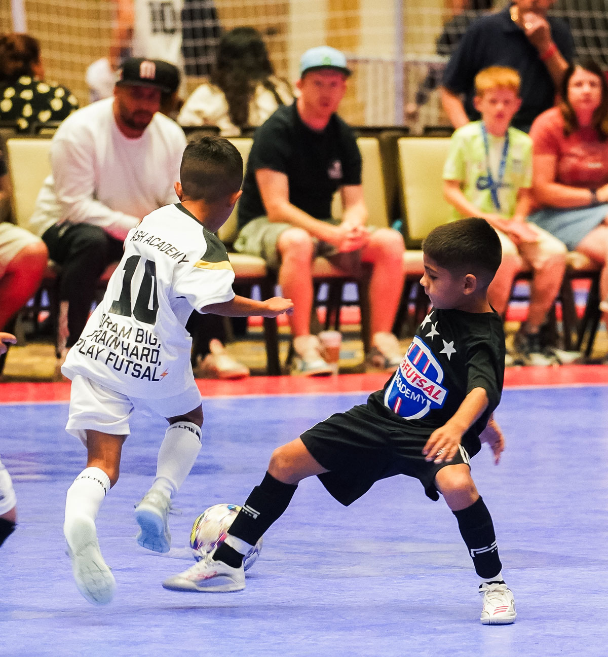 Two young boys playing futsal on the court